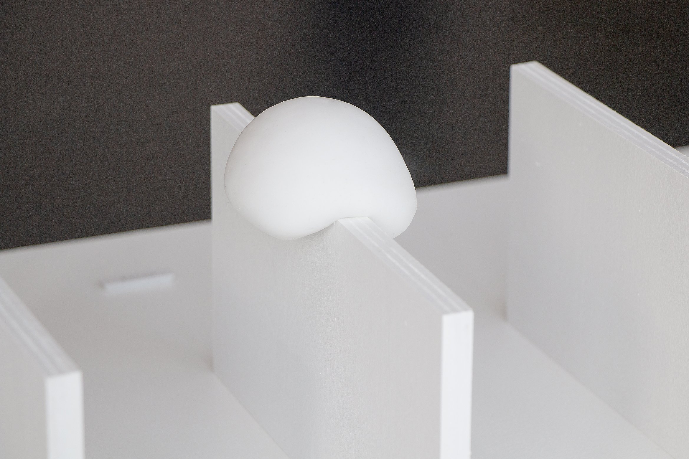 展示風景の写真。柔らかい球体が壁を乗り越えようとしている。別アングル