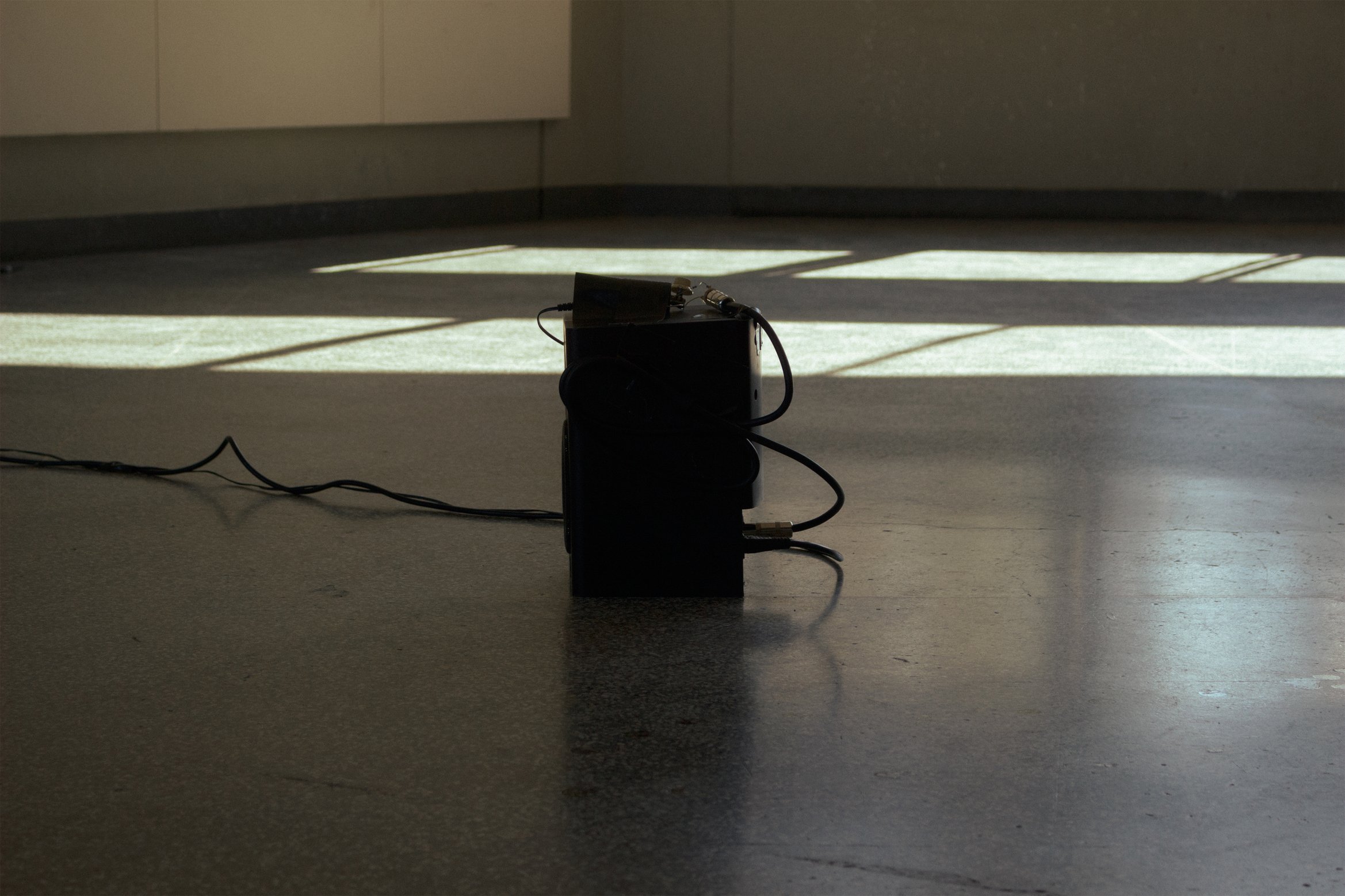 展示風景の写真。スピーカーが日差しが照らされた地面に置かれている。