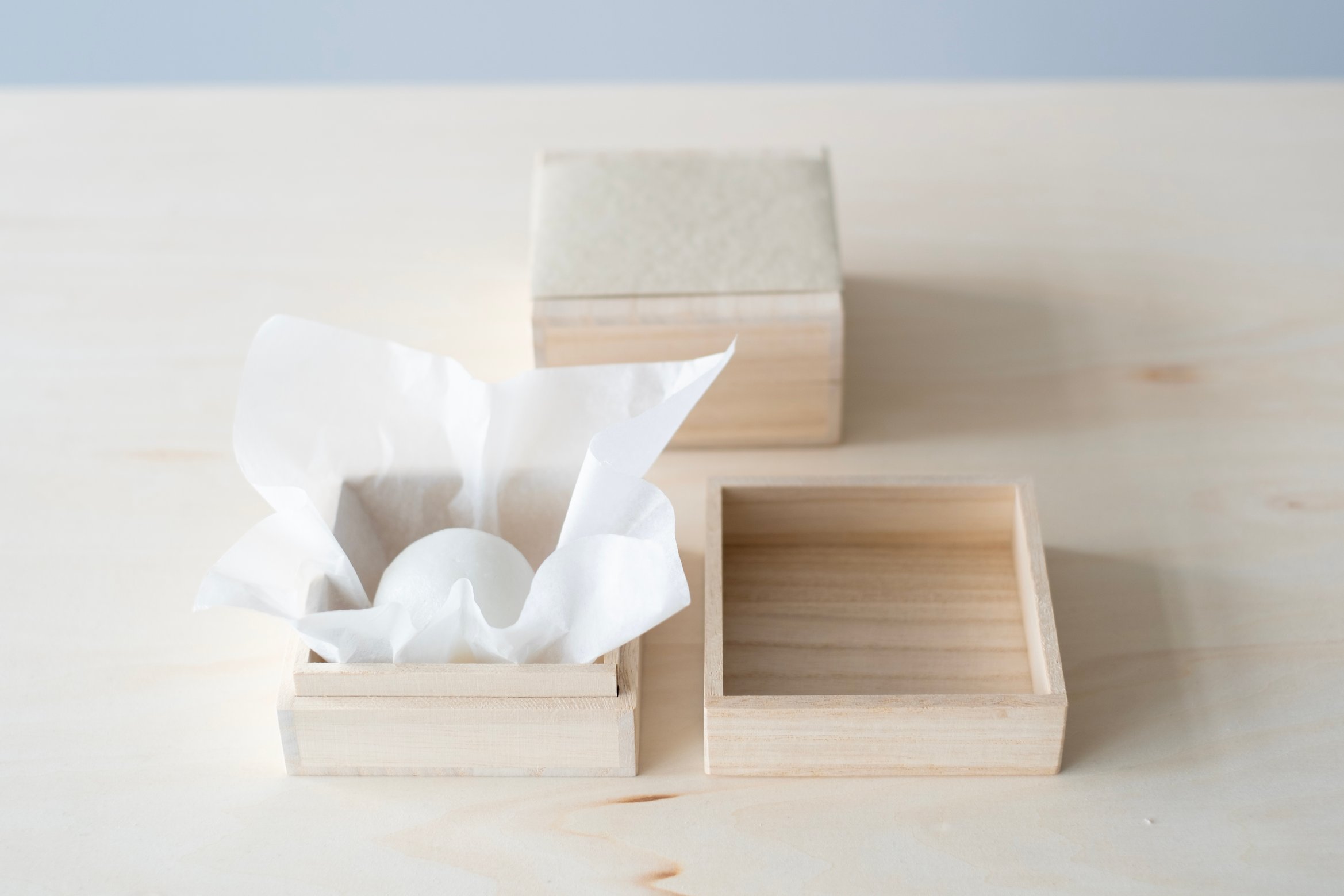 一つのまんじゅうが木箱によって包まれている。