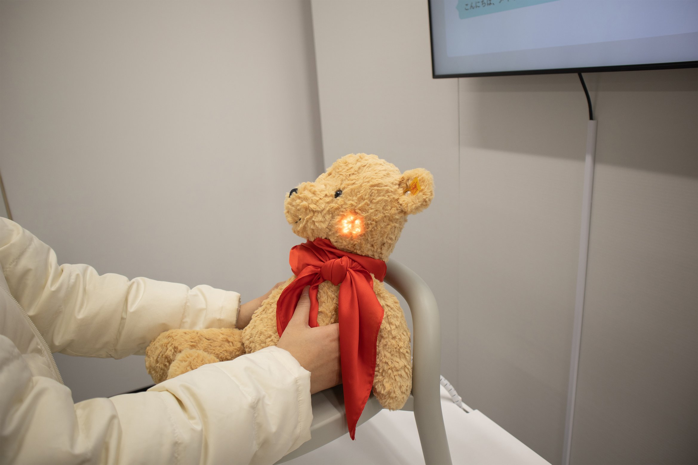 ラディベアのお腹をぎゅっと押しながら話しかけている写真