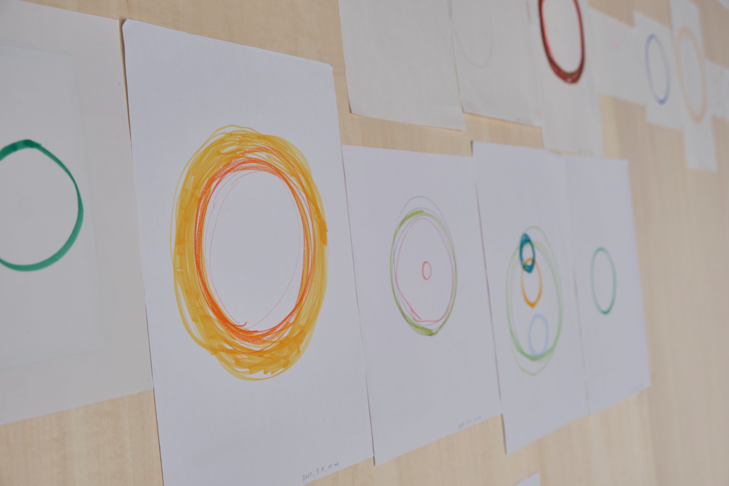 紙に丸が色鉛筆によって描かれている。